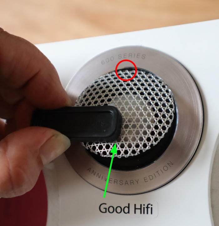 Platzieren Sie den Magneten des Werkzeugs auf der Unterseite des Metallgitters und heben Sie das Gitter an, sodass es oben (in der N&auml;he des roten Kreises) aufklappbar ist.